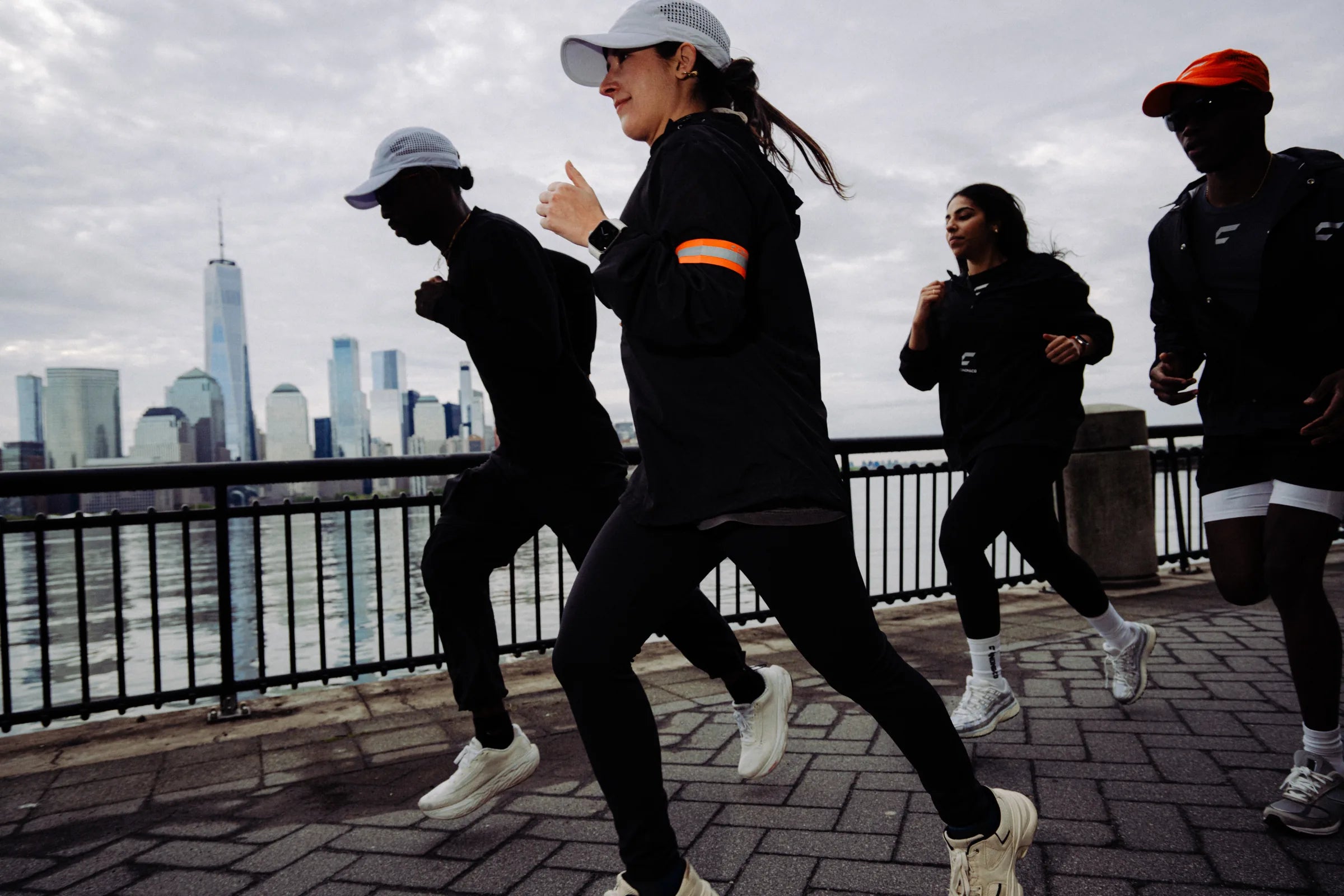 Cañon Running crew running the Jersey City waterfront with the Lower Manhattan skyline behind